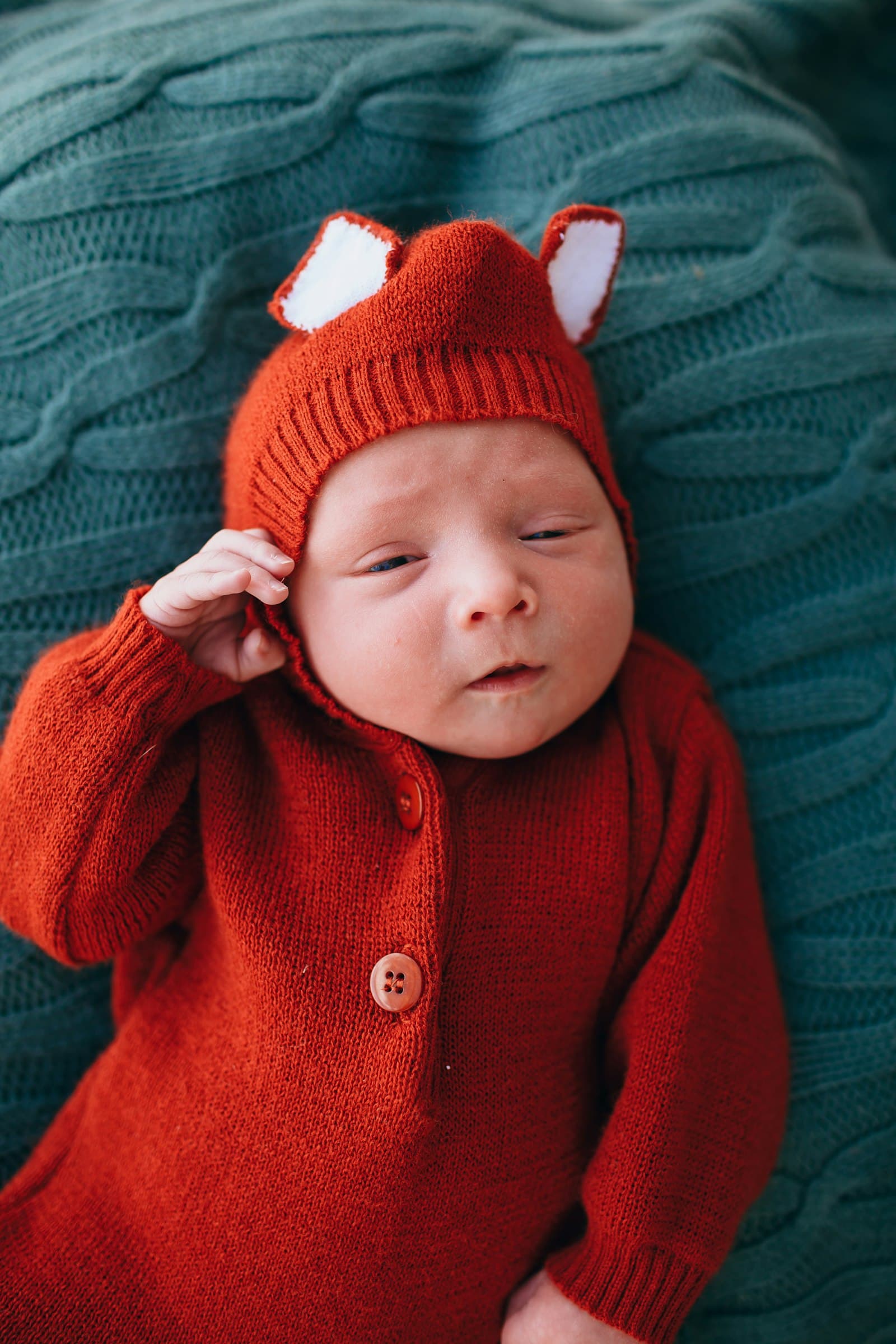 Baby in red knit cap and red knit sweater