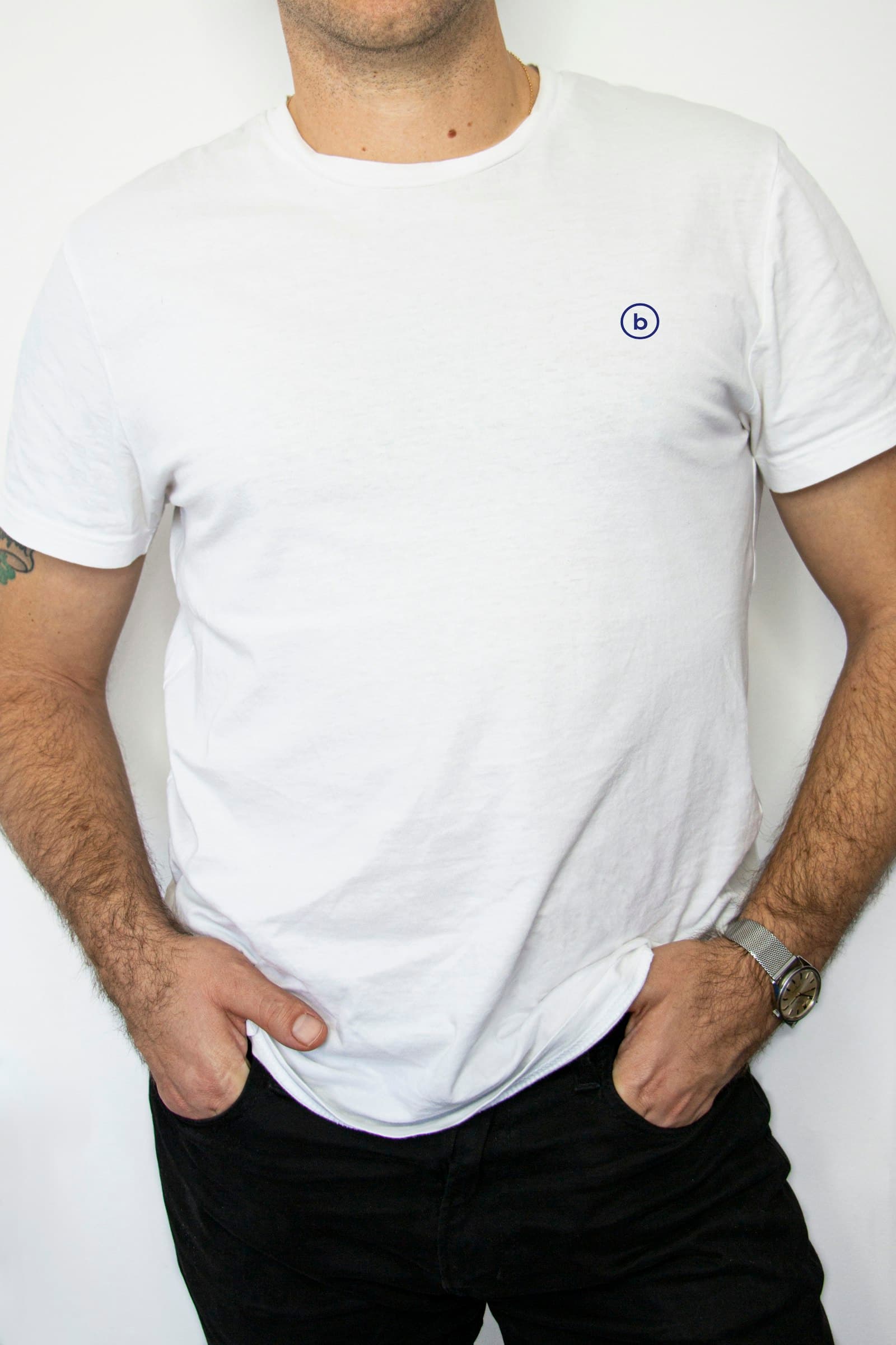 Man wearing white crew-neck shirt and black denim jeans with hands in pocket